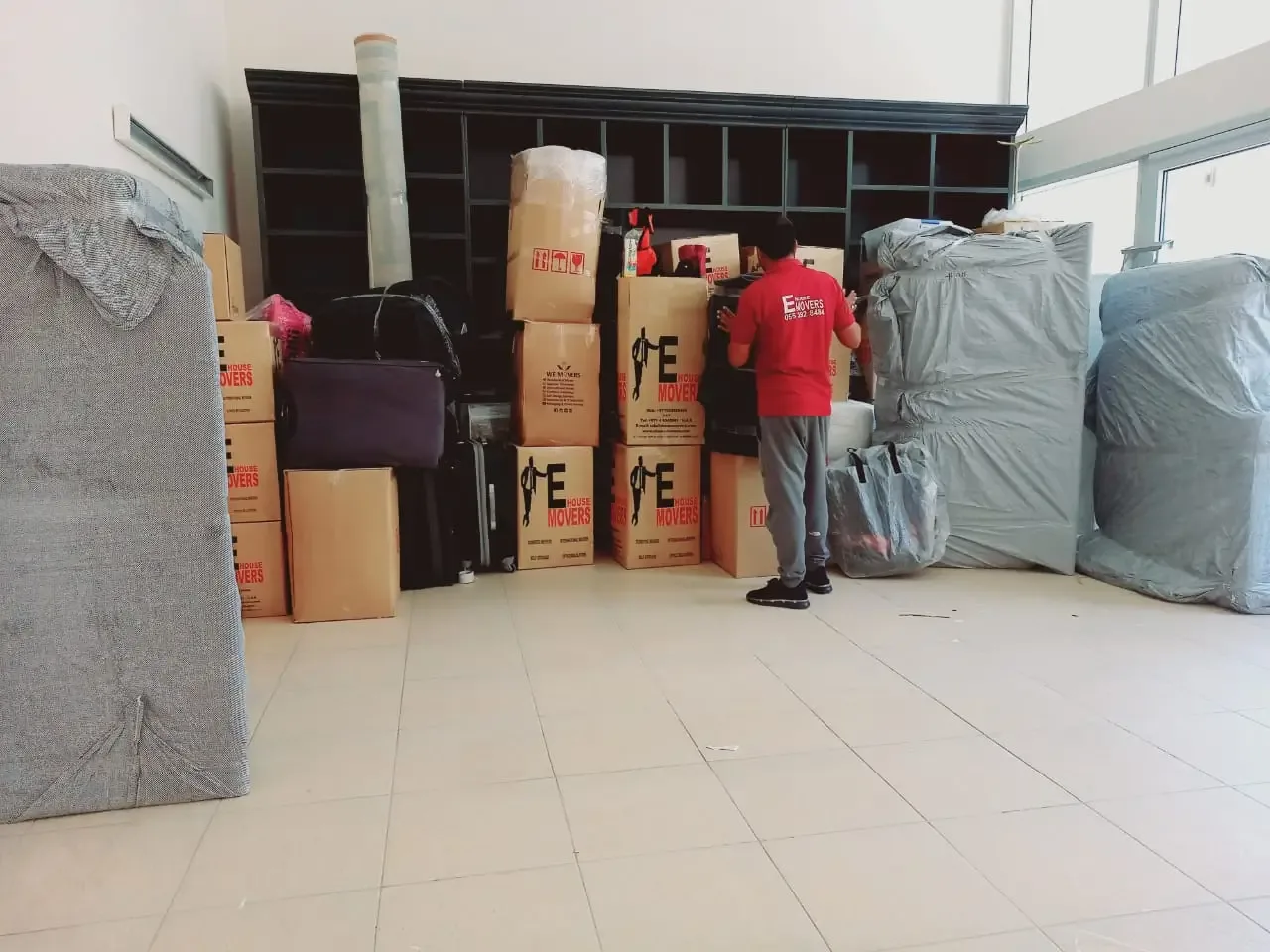 Apartment movers navigating a high-rise tower corridor in Al Quoz