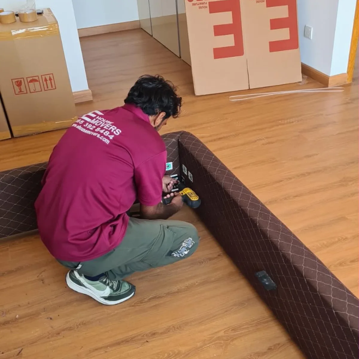 E House Movers mover assembling a bed frame