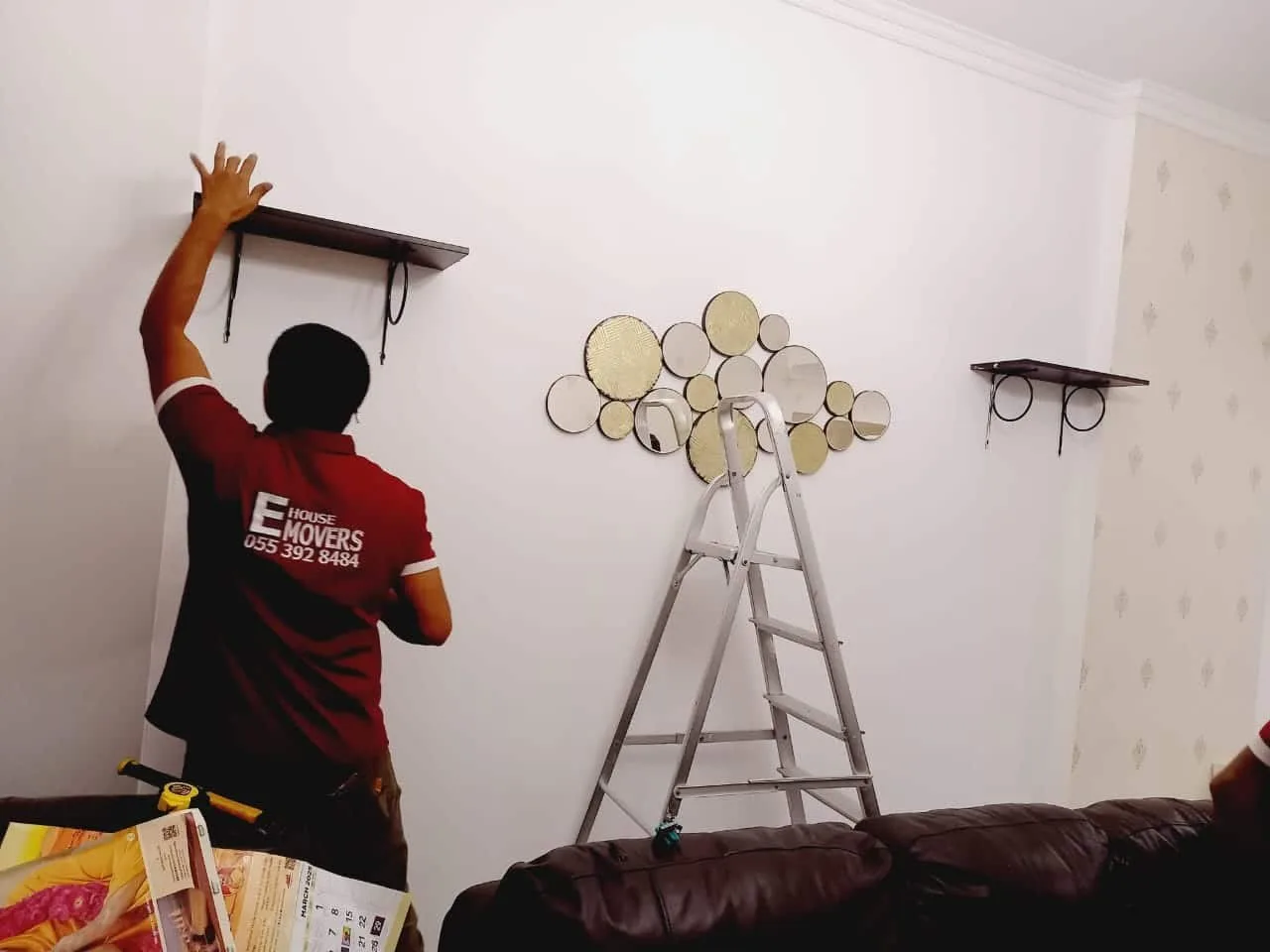 Office furniture movers handling desks and cabinets with protective wrapping