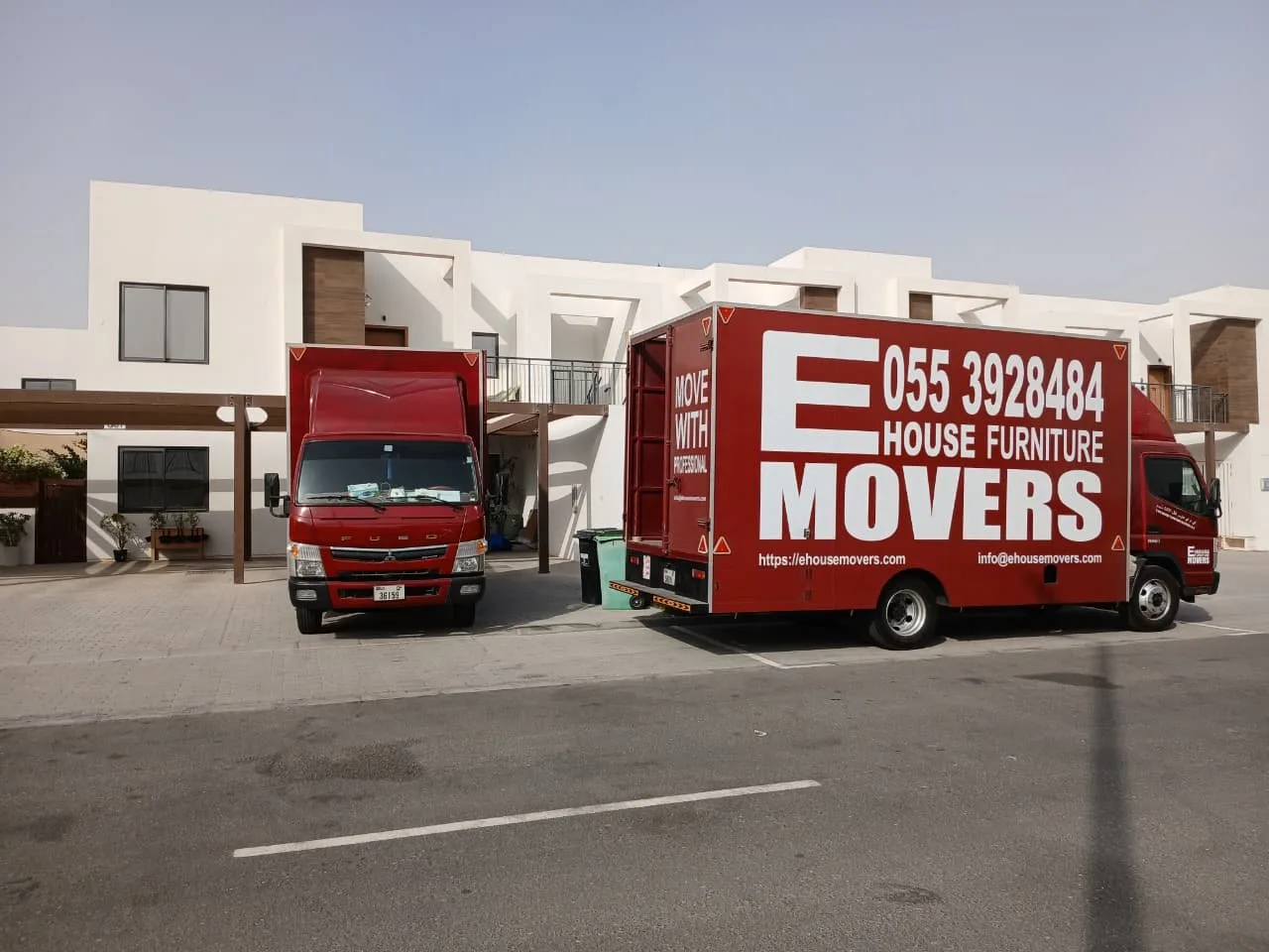 E House Movers trucks outside a home on moving day