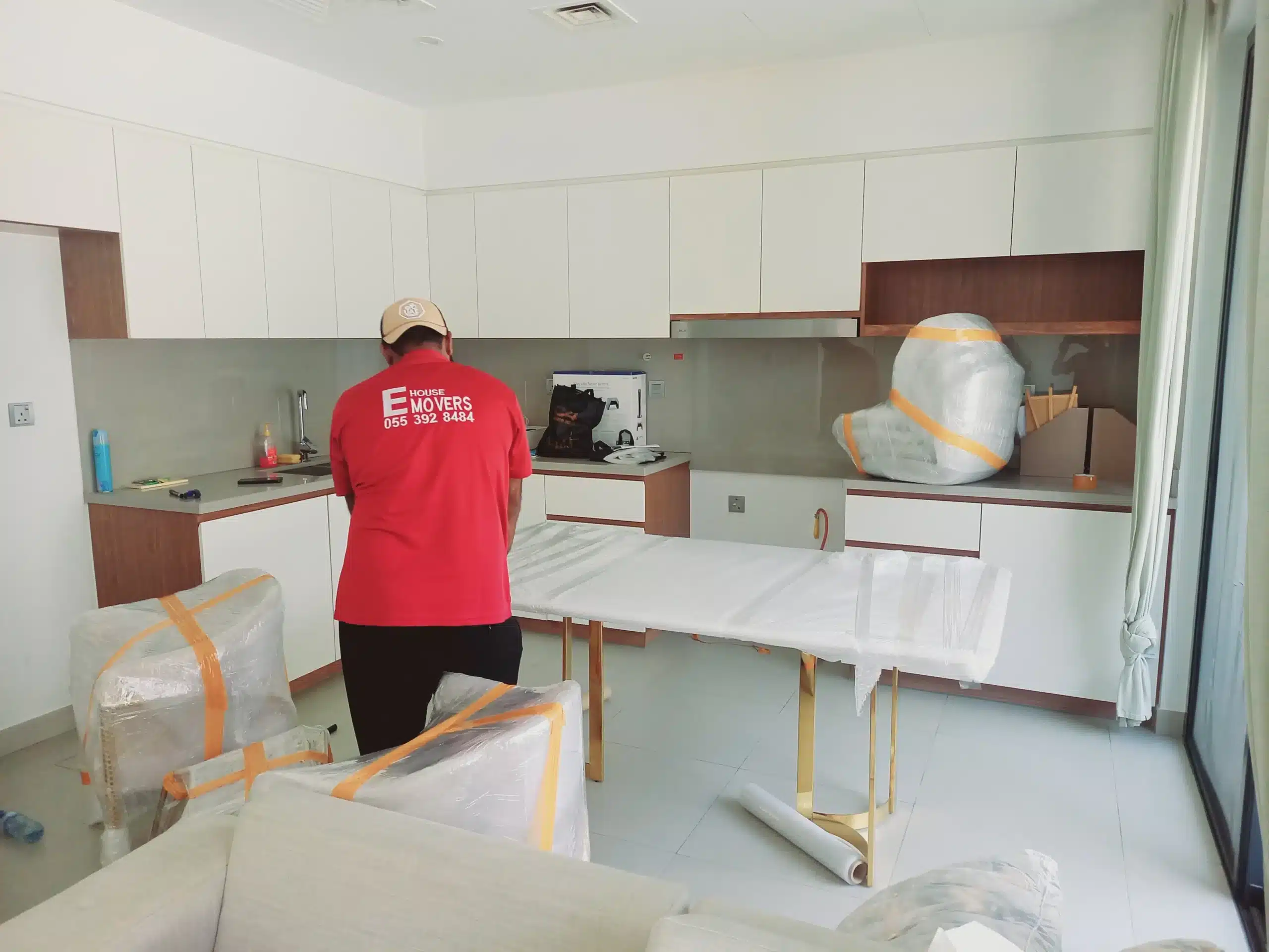 House movers packing kitchenware and appliances for a move in Al Quoz
